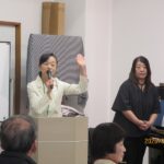 音楽会第１部　吉田記念館の職員で楽団員の司会進行役のご挨拶と自己紹介、お隣はピアノ奏者